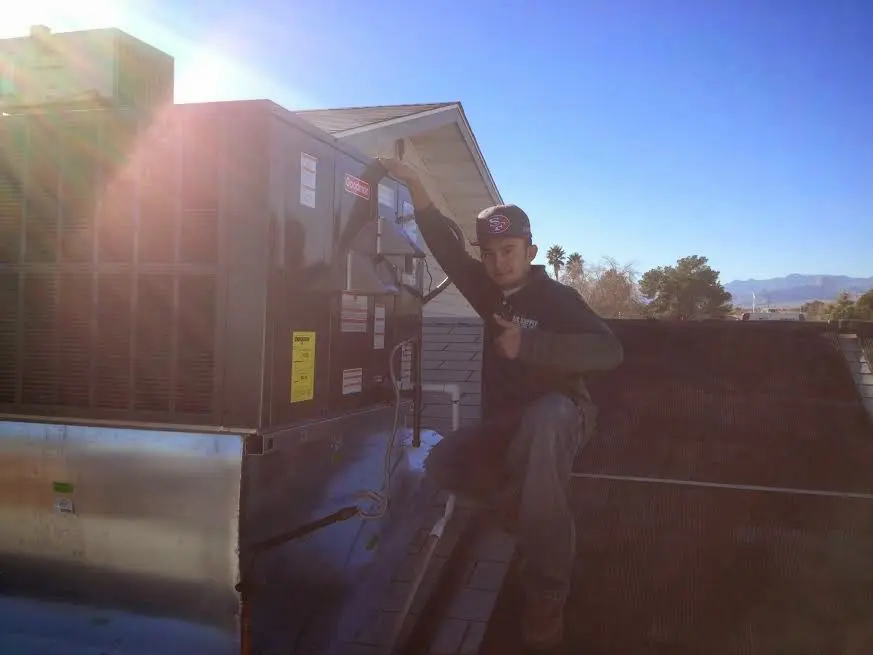 HVAC technician performing AC Tune-Up on a rooftop unit in Woodridge